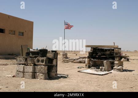 Die amerikanische Flagge fliegt hoch über den hausgemachten Barbecue-Grills am Hauptquartier der US Marine Corps (USMC) Marines mit Kilo/Company, 3. Bataillon, 23. Marine Regiment (Kilo 3/23) in AS Suwayrah, Irak, während der Operation IRAQI FREEDOM. Betroffene Operation/Serie: IRAKISCHE FREIHEITSBASIS: Als Suwayrah-Land: Irak (IRQ) Stockfoto