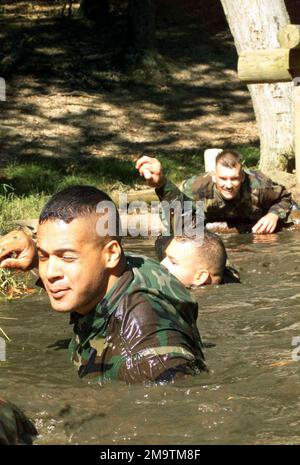 AUSBILDER des US Marine Corps (USMC) im Offiziersauswahl-Assistenten (OSA) gehen durch das Wasser- und Schlammkriechen-Hindernis für den Feldtrainingsteil der Marine Officers Candidate School auf der Marine Corps Base (MCB) Quantico, Virginia (VA). Die Ausbilder auf See absolvieren die Schulung, die sie den Kandidaten für die Offiziere, die an dem Kurs teilnehmen, später erläutern werden. Basis: Marinestützpunkt, Quantico Bundesstaat: Virginia (VA) Land: Vereinigte Staaten von Amerika (USA) Stockfoto