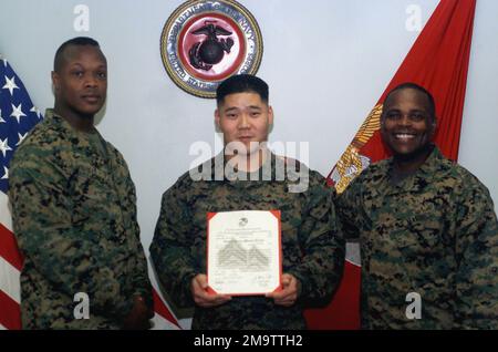 031103-M-4697Y-004. US Marine Corps (USMC) Corporal (CPL) Bonifacio Lee (Center), Training and Education (T&E) Command, gratuliert von USMC Marines aus seiner Einheit bei seiner Beförderungszeremonie an Bord der Marine Corps Base (MCB) Quantico, Virginia (VA). Stockfoto