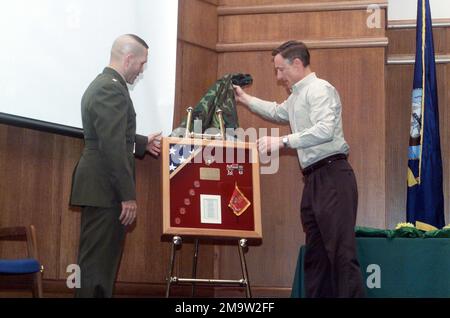 031124-M-4697Y-016. US Marine Corps (USMC) Major General (MGEN) Thomas S. Jones (rechts), kommandierender General, Training and Education (T&E) Command, enthüllt einen Erinnerungsrahmen, der ihn dem USMC Lieutenant Colonel (LCOL) Michael S. Haas während seiner Ruhestandszeremonie präsentiert, bei der er 21 Jahre engagierter Dienste für sein Land repräsentiert. Stockfoto