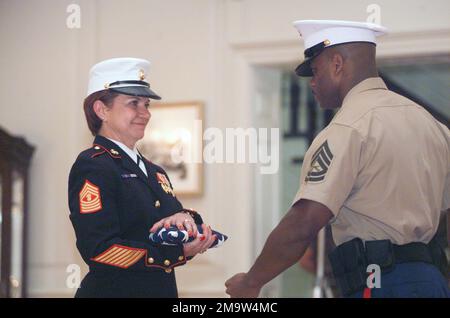 031031-M-9876R-021. US Marine Corps (USMC) Master Gunnery Sergeant (MGYSGT) Holly James (links) erhält während ihrer Ruhestandszeremonie in Harry Lee Hall an Bord der Marine Corps Base (MCB) Quantico, Virginia (VA) eine amerikanische Flagge. Stockfoto