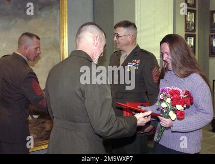 US Marine Corps (USMC) Brigadegeneral (BGEN) Joseph J. McMenamin (Vordergrundzentrum), kommandierender General, Marine Corps Recruit Depot (MCRD) Parris Island, South Carolina (SC), Und Sergeant Major (SGM) R. L. Ardnt präsentiert MASTER Sergeant (MSGT) Covert mit seinem Ruhestandszeugnis und Mrs. Covert einen Blumenstrauß während einer Zeremonie in Barrow Hall an Bord von MCRD, Parris Island, SC. Basis: USMC Recruit Depot, Parris Island Bundesstaat: South Carolina (SC) Land: Vereinigte Staaten von Amerika (USA) Stockfoto