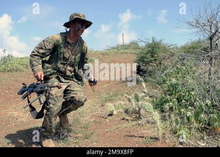 Während der Niederländischen bilateralen Ausbildung des US Marine Corps (USMC) Lance Corporal (LCPL) Stafford Boivin, USMC Reserves, ein FNMI 5,56mm M249 Squad Automatic Weapon (SAW)-Schütze bei Kilo Company, 3. Bataillon, 25. Marines, läuft nach dem Feuer von feindlichen Streitkräften in Curacao, Niederländische Antillen (ANT) in Deckung. Bilaterale Ausbildung ist ein jährlicher Kooperationsaustausch zwischen den USMC-Reserven und dem Royal Netherlands Marine Corps (RNMC). Land: Niederländische Antillen (ANT) Stockfoto