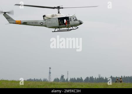 Staff Sgt. Zach Webster, 459. Airlift-Geschwader-Piloten, bereitet sich darauf vor, während des Friendship Festivals 2022 auf dem Yokota Air Base, Japan, am 21. Mai in ein UH-1N Iroquois gehoben zu werden. Die Demonstration war eines von vielen Veranstaltungen am Wochenende, bei denen die Fähigkeiten des US-Militärs gezeigt wurden. Stockfoto