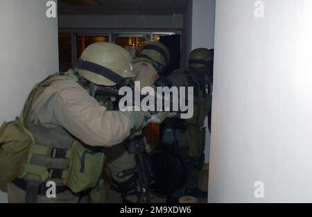 040211-M-6237R-019. [Complete] Szene Caption: US Marine Corps (USMC) Militärpolizei (MP), die dem Special Reaction Team (SRT) zugeteilt wurde. Stellen Sie sich hinter dem Schild in Stapelformation auf, während sie die Pacific Marine Credit Union betreten, während eines simulierten Banküberfalls im Marine Air Ground Combat Center in Twentynine Palms, Kalifornien (Kalifornien). Die jährliche Schulungsveranstaltung, die vom Büro des Generalstaatsanwalts durchgeführt wird, dient der Schulung der Militärpolizei und der Kriminalermittler in den richtigen Verfahren im Umgang mit Geiselnahmen. Abbildung von links nach rechts: Corporal (CPL) Stephen L. Clogston, CPL Robert Stockfoto
