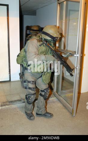 US Navy (USN) Hospital Corpsman Third Class (HM3) Thomas J. Cupo, ein Mitglied des Special Reaction Team (SRT), ist mit einem Heclker und Koch 9mm MP5-N Submaschinengewehr bewaffnet, da er Schutz für seine Teammitglieder bietet, die die Pacific Marine Credit Union betreten; Während eines simulierten Banküberfalls im Marine Air Ground Combat Center in Twentynine Palms, Kalifornien (Kalifornien). Die jährliche Schulungsveranstaltung, die vom Büro des Generalstaatsanwalts durchgeführt wird, dient der Schulung der Militärpolizei und der Kriminalermittler in den richtigen Verfahren im Umgang mit Geiselnahmen. Basis: Twentynine Palms Staat: Kalifornien (CA) C Stockfoto