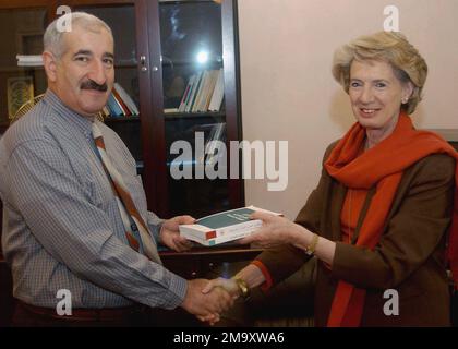 Seine Exzellenz Dr. Abdul Basit Turki Said (links), irakischer Minister für Menschenrechte, akzeptiert im Namen seiner Mitarbeiter zwei Bücher von Frau Audrey Glover (rechts), LEITENDE Beraterin der Provisorischen Behörde der Koalition (CPA) für Menschenrechte und Übergangsjustiz. Frau Glover hat Dutzende Bücher und Broschüren über Menschenrechtsgesetze und -Konventionen gespendet, die in arabischer Sprache geschrieben wurden, um die Referenzbibliothek des Ministeriums├aufzubauen. Basis: Bagdad Land: Irak (IRQ) Stockfoto