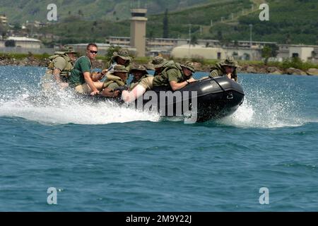 Mitarbeiter des US Marine Corps (USMC) aus DEM 1. Bataillon, dem 3. Marine Regiment, fahren in einem Zodiac Rigid Hull Inflatable Boat (RHIB), während es durch das Wasser schneidet, während die Schiffsnavigation auf der Marine Corps Base (MCB) Hawaii (HI) stattfindet. Basis: MCB, Hawaii Bundesstaat: Hawaii (HI) Land: Vereinigte Staaten von Amerika (USA) Stockfoto