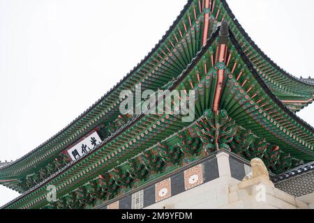 Seoul, Korea. 21. Dezember 2022. Gyeongbokgung Palast Vordertore an einem verschneiten Wintertag. Gyeongbokgung Palast ist ein historischer Palast im Norden von Seoul. Es wurde 1395 während der Joseon-Dynastie erbaut und diente über 500 Jahre lang als königlicher Palast. Der Palast wurde restauriert und ist für die Öffentlichkeit für Touren zugänglich. Besucher können die wunderschöne Architektur sehen und mehr über die Geschichte des Palastes und der Joseon-Dynastie erfahren. Auf dem Palastgelände befinden sich verschiedene Gebäude, darunter die Thronhalle, die große Halle und das Nationale Volksmuseum von Korea. Besucher können auch Zeuge der werden Stockfoto