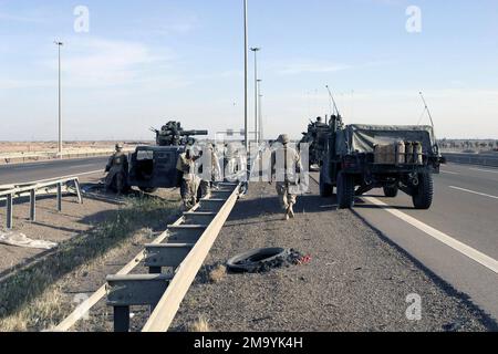 US Marines Corps (USMC) Marines mit 2. Bataillon, 1. Marine Regiment, 1. Marine Division, verwenden High-Mobility Multipurpose Wheeled Vehicles (HMMWV), eines mit einem M220 Abschleppsystem (Tube-launed, optically-tracked, Wire-guided) System und Light Panzer Vehicle-25 (LAV-25), um einen Teil des Highway 1 während der IRAKISCHEN Operation FREIHEIT in Fallujah, Irak, zu sichern. Die Marines des USMC unterbrachen den Verkehr in die Stadt, um terroristische Kräfte, die für die jüngsten Angriffe auf die Koalitionsstreitkräfte verantwortlich sind, zu isolieren und auszumerzen. Operation/Serie: IRAKISCHE FREIHEITSBASIS: Fallujah Staat: Al Anbar Land: Irak (IRQ) Stockfoto