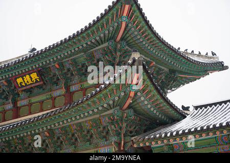 Seoul, Korea. 21. Dezember 2022. Gyeongbokgung Palast Vordertore an einem verschneiten Wintertag. Gyeongbokgung Palast ist ein historischer Palast im Norden von Seoul. Es wurde 1395 während der Joseon-Dynastie erbaut und diente über 500 Jahre lang als königlicher Palast. Der Palast wurde restauriert und ist für die Öffentlichkeit für Touren zugänglich. Besucher können die wunderschöne Architektur sehen und mehr über die Geschichte des Palastes und der Joseon-Dynastie erfahren. Auf dem Palastgelände befinden sich verschiedene Gebäude, darunter die Thronhalle, die große Halle und das Nationale Volksmuseum von Korea. Besucher können auch Zeuge der werden Stockfoto