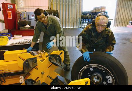 040413-F-9032T-007. [Complete] Szene Caption: US Air Force (USAF) STAFF Sergeants (SSGT) Jessica Oviedo (rechts) und John Overby, Crewchiefs, 48. Equipment Maintenance Squadron (EMS), 48. Fighter Wing (FW), RAF (Royal Air Force) Lakenheath, Vereinigtes Königreich (UK), entfernt ein C-Hauptrad von der Perlenbrechmaschine. Durch das Brechen der Wulst wird der Reifen vom Rad gelöst. Das 48. EMS bietet die Wartung auf mittlerer und organisatorischer Ebene für drei Kampfgeschwader zur Unterstützung der 48. FW, der US Air Forces in Europe (USAFE), des US European Command und der NATO (North Atlantic Treaty Organization) Stockfoto