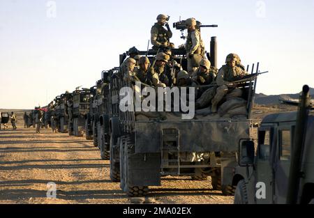 Mitarbeiter des US Marine Corps (USMC) vom 2. Bataillon, 5. Marines, 1. Marine Division, Camp Pendleton, warten in ihren MTVR-Lkws (Medium Tactical Vehicle Replacement), um eine Konvoi-Übung im Marine Corps Air Ground Combat Center (MCAG) in Twenty-Nine Palms, Kalifornien, zu beginnen. Zur Vorbereitung ihres Einsatzes in Irak (IRQ). Basis: Twentynine Palms Bundesstaat: Kalifornien (CA) Land: Vereinigte Staaten von Amerika (USA) Stockfoto