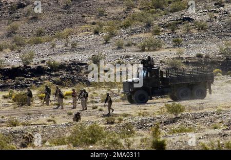 US Marine Corps (USMC) Marines, 2. Bataillon (BN), 11. Marines Regiment, in Schlange vor einem 7,5-Tonnen-taktischen mitteltaktischen Vehicle Replacement (MTVR)-Truck, Während der Durchführung von Live-Feuerübungen während des Trainings im Konvoi im Marine Corps Air Ground Combat Center (MCAGCC) Marine Air Ground Task Force Training Center (MAGTFTC) 29 Palms, Kalifornien (Kalifornien). Die Ausbildung im Konvoi-Einsatz ist nun Teil der allgemeinen CAX-Ausbildung (Combined Arms Exercise), da sich die Kampagneneinsätze im Rahmen der Operation „IRAQI FREEDOM“ geändert haben. Basis: MCAGCC, Twentynine Palms Bundesstaat: Kalifornien (CA) Land: Stockfoto