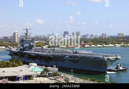 Ein Viertel Steuerbord-Bugblick der US Navy (USN) ENTERPRISE-KLASSE: Aircraft Carrier, USS ENTERPRISE (CVN 65), zeigt Seeleute, die die Schienen bemannt, während das Schiff von einem kommerziellen Schlepper unterstützt wird, während es anlegt in Port Everglades, Florida (FL), während der jährlichen Flottenwoche. Basis: Port Everglades Bundesstaat: Florida (FL) Land: Vereinigte Staaten von Amerika (USA) Stockfoto