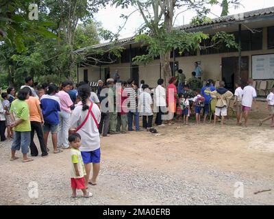 040512-M-4688C-007. Die Patienten stehen vor einer temporären medizinischen Klinik, die in einer Ban Khok Wat Grundschule von Marines des US Marine Corps (USMC) und Personal der US Navy (USN) eingerichtet wurde, Marine Expeditionary Unit (MEU) Service Support Group 31 (MSSG-31), 31. MEU SOC (Special Operations Capable), Amphibious Squadron 11 (PHIBRON 11), Essex Amphibious Ready Group (ARG) Die MSSG-31 arbeitet mit Marines des Royal Thai Marine Corps (RTMC) in einem kombinierten medizinisch-zahnärztlichen Gemeinschaftsprojekt (Med/Den CAP) zusammen, das medizinische und zahnärztliche Hilfe für die lokale ländliche Bevölkerung in einer provisorischen Klinik bereitstellt Stockfoto