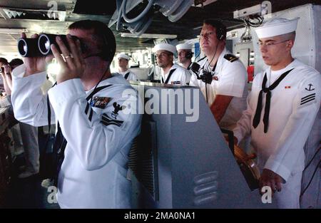 US Navy (USN) Operations SPECIALIST First Class (OS1) Daniel K. Bearden (Vordergrund links) verwendet ein Fernglas, um den Horizont zu begradigen, während er einen Wachposten auf der Brücke an Bord der USN NIMITZ-KLASSE bedient: Aircraft Carrier USS RONALD REAGAN (CVN 76). Basis: USS Ronald Reagan (CVN 76) Stockfoto