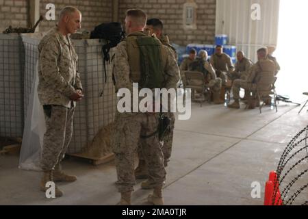 US Marine Corps (USMC) Brigadegeneral (BGEN) John F. Kelly (links), Stellvertretender Befehlshaber der Division, 1. Marine Division (MAR DIV), spricht während der Operation „IRAQI FREEDOM“ mit Marines der Bravo Company, 1. Bataillon (BN), 5. Marines (MAR DIV), 1. Marine Division (MAR DIV) bei einem Besuch in Al Shahabi, Irak. BGEN Kelly begleitete Generalleutnant Thomas F. Metz (Hintergrund) der US-Armee (USA), der General III Corps befehligte, in die Region. Die MAR DIV 1. ist in der Region in Sicherheits- und Stabilisierungsoperationen (SASO) tätig. Basis: Al-Shahabi-Staat: Al-Anbar-Land: Irak (IRQ) Stockfoto