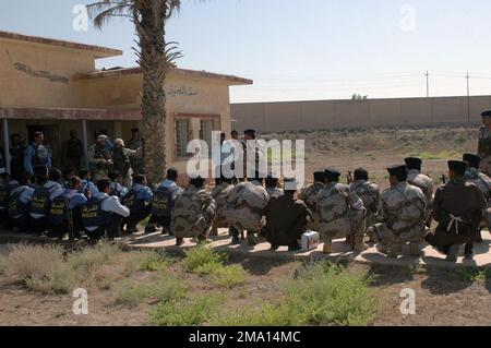 040606-M-5555L-123. [Complete] Szene Caption: Soldaten des irakischen Zivilschutzkorps (ICDC) und Offiziere der irakischen Polizei (IP), bewaffnet mit 5,56-mm-Tabuk-Sturmgewehren, versammeln sich, um einen Bericht über die Nachaktion anzuhören, der vom irakischen Oberstleutnant Salah, POLIZEICHEF der irakischen Polizeistation Al Horeiya, verfasst wurde. Akarm, Major (MAJ) des irakischen Zivilschutzkorps (ICDC), S-3 Offizier, der der 501. Brigade zugewiesen wurde, im Anschluss an die Razzia des Praxishauses, die in der Nähe des Camp Hurricane Point durchgeführt wurde, am Stadtrand von Ar Ramadi, Irak. SOLDATEN DER US-Armee (USA), die dem US Marine Corps (USMC) 1. Marine Divis angeschlossen sind Stockfoto