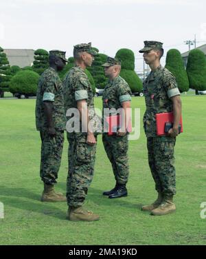 040609-M-3843C-064. [Complete] Szene Caption: US Marine Corps (USMC) GUNNERY Sergeant (GYSGT) Scott Cooper (Hintergrund links) und USMC Colonel (OBERST) Stephen Fenstermacher (Vordergrund links), Commander, Marine Wing Support Group One Seven (MWSG-17), überreicht die Bronze Star Medal (mit Kampfunterscheidungsgerät) USMC Sergeant (SGT rechts), Lauritzen (Hintergrund rechts) Und USMC SGT Mauricio Guevara, beide Kampfeingenieure, die während einer Preisverleihung an Bord der Marine Corps Air Station (MCAS) Iwakuni, Japan, der Marine Wing Support Squadron One Seven One (MWSS-171) zugeteilt wurden. Beide Marines wurden ausgezeichnet Stockfoto