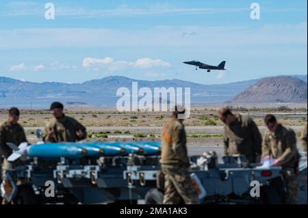 USA Air Force-Flieger vom 366. Fighter Wing, Mountain Home Air Force Base, Idaho, beobachten, wie ein F-15E Strike Eagle am Wendover Airfield, Wendover, Utah, 21. Mai 2022 vorbeifliegt. Der 366. Fighter Wing verfügt über zwei Kampfgeschwader, die den F-15E Strike Eagle fliegen: Das 389. Fighter Squadron und das 391. Fighter Generation Squadron. Stockfoto