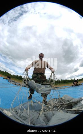 040612-F-3488S-012. [Complete] Bildunterschrift: US Army (USA) SPECIALIST Fourth Class (SPC) Timothy Wolfley, Parachute Rigger, Special Forces Operations (SFO) Detachment (DET) 144, Alpha Company (A CO), 2. Bataillon (BN), 1. Special Forces Group (Airborne), Fort Lewis, Washington (WA), Beim HALO-Training (High Altitude Low Opening) im Rahmen der Übung NORTHERN EDGE 04 wird zwischen den Sprüngen ein Fallschirm nachgerüstet. NORTHERN EDGE ist die jährliche gemeinsame Schulung von Alaska (AK), die darauf abzielt, die Interoperabilität zwischen den Diensten zu verbessern und die Techniken und Verfahren der gemeinsamen Dienste zu verbessern. Es hilft bei der Bereitstellung eines Stockfoto