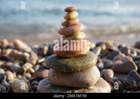 Eine Nahaufnahme von Cairn am Strand mit dem Meer im Hintergrund Stockfoto