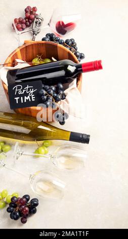 Weinprobe. Ein Foto von Gläsern Rot- und Weißwein mit einer Flasche, Trauben, und einem altmodischen Korkenzieher und Korken, von oben auf einem Lichtb aufgenommen Stockfoto