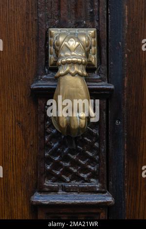 Blick aus der Nähe auf einen eleganten, handisolierten, altbraunen Türklopfen aus altem Messing, Montpellier, Frankreich Stockfoto