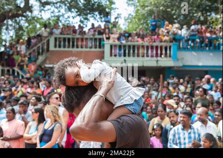 Kuilapalayam, Indien - 17. Januar 2023: Pongal Festival. Das Publikum wartet auf die Parade und das Rennen. Ein Kind bedeckt sich die Ohren wegen des Lärms. Stockfoto