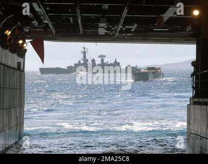 040706-N-4304S-106. [Complete] Scene Caption: A US Navy (USN) Landing Craft Utility (LCU) nähert sich dem Brunnendeck des USN Tarawa Class Amphibious Assault Ship USS TARAWA (LHA-1), während die chilenische (Armada de Chile (Ach)) Leander Class Frigate LYNCH (FFG 07) in den Gewässern direkt hinter dem Schiff arbeitet. TARAWA und LYNCH sind zwei von vielen Marineschiffen, die an Übung Rim of the Pacific (RIMPAC) 2004 teilnehmen. RIMPAC ist die größte internationale Seefahrt-Übung in den Gewässern rund um die hawaiianischen Inseln. Dieses Jahr sind sieben teilnehmende Länder beteiligt: Australien, Kanada, Chile, J. Stockfoto