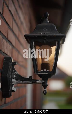 Alte Straßenlampe an der Wand mit einer modernen Lampe Stockfoto