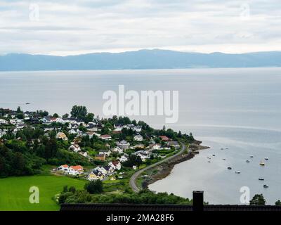 Ein Blick auf ein Dorf am Arm des Trondheimsfjords. Die skandinavischen Länder verfügen alle über einzigartige Landschaften, die nur dort zu finden sind. Daher ist es nicht überraschend, dass die skandinavischen Länder das ganze Jahr über unzählige Touristen empfangen. Schweden verfügt auch über mehr als tausend Meilen Küste. Jeder in Schweden kann die Wälder, die Berge, die Seen und das Meer genießen, dank des so genannten jedermanns Rechts. Weit oben im Norden sind die Sommer besonders besonders, weil die Sonne ein paar Wochen lang gar nicht untergeht, immer noch um Mitternacht scheint und die umliegenden Landschaften in Spe verwandelt Stockfoto