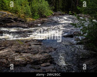 Ein Blick auf einen Fluss, der viel Wasser aus den schwedischen Bergen transportiert. Die skandinavischen Länder verfügen alle über einzigartige Landschaften, die nur dort zu finden sind. Daher ist es nicht überraschend, dass die skandinavischen Länder das ganze Jahr über unzählige Touristen empfangen. Schweden verfügt auch über mehr als tausend Meilen Küste. Jeder in Schweden kann die Wälder, die Berge, die Seen und das Meer genießen, dank des so genannten jedermanns Rechts. Weit oben im Norden sind die Sommer besonders besonders, da die Sonne ein paar Wochen lang gar nicht untergeht, immer noch um Mitternacht scheint und die umliegenden Landschaften umwandelt Stockfoto