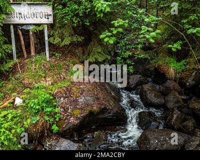 A view of a small waterfall surrounded by plants and trees. Nordic countries all boast unique landscapes that can only be found there, so it's no surprise that Scandinavian countries receive countless tourists all year round. Sweden also has more than a thousand miles of coastline. Everyone in Sweden can enjoy the forests, the mountains, the lakes, and the seaside because of the so-called everyman's Right. Far up in the North, the summers are particularly special because, for a few weeks, the sun doesn't set at all, still shining at midnight, converting the surrounding landscapes into spectacu Stock Photo