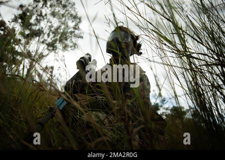 USA Marinekorps Sergeant Terrance Jones, ein gemeinsamer Terminal-Angriffscontroller, mit Lima Company, 3D. Bataillon, 7. Marineregiment, Bodenkampfelement, Marine Rotational Force-Darwin 22, Patrouillen während eines nicht tödlichen Trainings als Teil der Übung Southern Jackaroo 22 im Shoalwater Bay Trainingsbereich, Queensland, Australien, 24. Mai 2022. Das weniger als tödliche Training umfasste ein Kampfszenario mit Schimmelmunition und wechselte zu einem Massenszenario mit Opfern, in dem die verletzten Rollenspieler untersucht, behandelt und dann in eine höhere Abteilung der Pflege transportiert wurden. Stockfoto