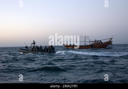 Matrosen DER US Navy (USN) und Marines des US Marine Corps (USMC) an Bord eines RHIB (Rigid Hull Inflatable Boat), das dem Special Boat Team 20 (SBT-20) zugewiesen ist, leiten eine Fischerdau um, die in der Nähe von US-Marineschiffen im nördlichen Arabischen Meer herumlungert. SBT-20 führt maritime Abfangoperationen (MIO) zur Unterstützung der Operationen DAUERHAFTE FREIHEIT/IRAKISCHE FREIHEIT durch. Betrifft Operation/Serie: DAUERHAFTE FREIHEIT/IRAKISCHE FREIHEIT Land: Arabisches Meer Stockfoto