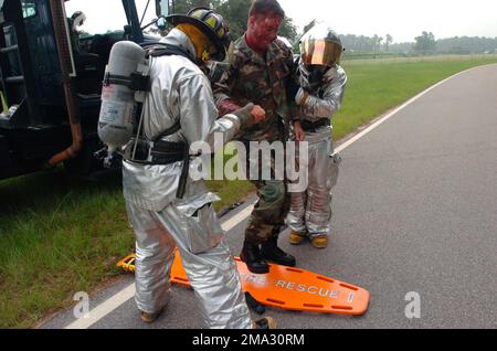 040817-F-0629H-009. [Complete] Szene Caption: 040817-F-0629H-009 (17. Aug. 2004)Firefighters Gregory Farley (links) und US Air Force (USAF) SENIOR AIRMAN Brandon Albrecht, beide mit dem 20. Bauingenieurschwadron (CES), Shaw Air Force Base (AFB), South Carolina (SC), in Joint Firefighter Integrated Response Ensembles (MOPP), 4 Postern (JFIRE) Entfernen Sie USAF MASTER Sergeant (MSGT) Rick Smith, 20. Aeromedizin-Dental-Geschwader, ein simuliertes Opfer, vom Tatort eines MARE-Szenarios auf der Patrouillenstraße am Stützpunkt. Notfalldienst ag Stockfoto