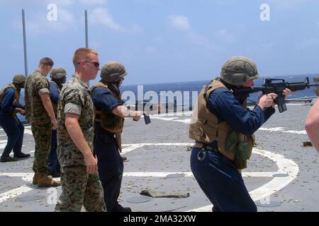 060512-N-4124C-054. [Complete] Scene Caption: An Bord des Flugdecks des Amphibious Transport Dock der US Navy (USN), USS JUNEAU (LPD 10), USN Captain (CAPT) John D. Alexander (Vordergrund), der kommandierende Offizier der Schiffe (CO), feuert eine 5,56 mm große Karbine M4A1 ab, Während eines von der Besatzung gedienten Schießerei mit Marines des US Marine Corps (USMC), die der 31. Marine Expeditionary Unit (MEU) zugeteilt wurden. Die JUNEAU- und USMC-Marines sowie die USN-Matrosen, die der vorwärts eingesetzten Amphibious Ready Group zugeteilt sind, befinden sich derzeit im Südchinesischen Meer auf dem Weg zur Teilnahme an der Übung COBRA GOLD 2006. Stockfoto