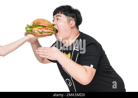 Ein fettleibiger junger Mann fiel auf das Essen Stockfoto