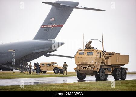 USA Armeesoldaten, zugewiesen zu Bravo Battery, 1. Bataillon, 14. Artilleriegesiment, 75. Artilleriebrigade und USA Air Force Airmen, zugeteilt in 167. Airlift Wing, West Virginia, Air National Guard, entlädt und beschäftigt ein Mehrzweckfahrzeug mit Mobilitätsantrieb (HMMWV oder Humvee) und ein M142 High Mobility Artillery Rocket System während einer HIMARS Rapid Infiltration im Rahmen von DEFENDER-Europe 22 in Bornholm, Dänemark, 24. Mai 2022. DEFENDER-Europe 22 ist eine Serie von US-amerikanischen Multinationale Ausbildungsübungen der Armee in Europa und Afrika innerhalb der USA European Command's Large Global Scale Ex Stockfoto