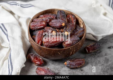 Dattelfrucht auf dunklem Hintergrund. Bio-Medjoul-Datteln in der Schüssel. Ramadan-Essen. Nahaufnahme Stockfoto