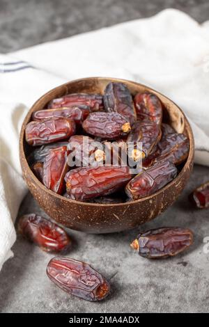 Dattelfrucht auf dunklem Hintergrund. Bio-Medjoul-Datteln in der Schüssel. Ramadan-Essen. Nahaufnahme Stockfoto