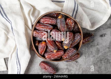 Dattelfrucht auf dunklem Hintergrund. Bio-Medjoul-Datteln in der Schüssel. Ramadan-Essen. Draufsicht Stockfoto