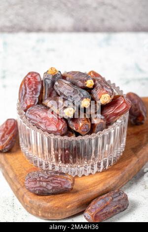 Dattelfrucht auf Steinhintergrund. Organische Medjoul-Datteln in einer Glasschüssel. Ramadan-Essen. Schließen Stockfoto