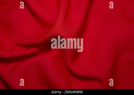 Roter Stoffhintergrund. Rotes Tuch Wellen Hintergrundstruktur. Rotes Stoffgewebe Textilmaterial. Stockfoto