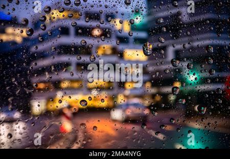 Blick durch eine regenüberflutete Windschutzscheibe auf eine Straßenszene in Frankfurt Stockfoto