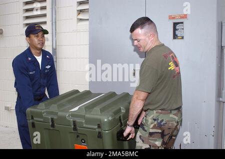 041231-N-3207B-001. [Complete] Scene Caption: US Navy (USN) Lieutenant (LT) Pete Obenauer und USN Hospital Corpsman Second Class (HM2) Richard Cabatit, Naval Environmental and Preventive Medicine Unit 6 (NEPMU-6) tragen ein Entomologie-Vektorüberwachungs- und -Steuerungsset zu einem Uploadpunkt, während sie sich auf den Einsatz nach Indonesien vorbereiten. Die Entomologie-Kits werden verwendet, um Moskitos, Zecken und andere krankheitserregende Insekten zur Untersuchung und möglichen Vernichtung zu fangen, wenn festgestellt wird, dass sie Träger von Malaria oder Dengue-Fieber sind. Die NEPMU-6 entsendet nach Indonesien, um humanitäre Hilfe zu leisten Stockfoto