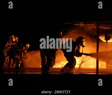 US Marine Corps (USMC) Fire Fighters, die der Aircraft Rescue and Fire-Fighting (ARFF) zugewiesen sind, trainieren, um Feuer in der Feuerstelle des Scheinflugzeugs zu löschen, an Bord der Marine Corps Air Station Beaufort, South Carolina (SC). Basis: MCAS, Beaufort Bundesstaat: South Carolina (SC) Land: Vereinigte Staaten von Amerika (USA) Stockfoto