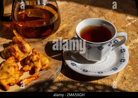 Köstliche Süßkartoffeln-Pommes mit Kräutertee auf einem Holztisch Stockfoto